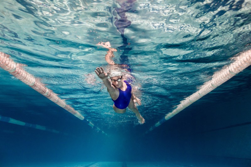 Schwimmerin krault im Schwimmbad unter Wasser
